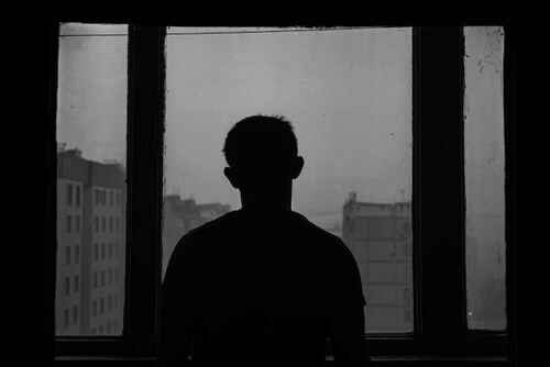 depressed man looking out of window